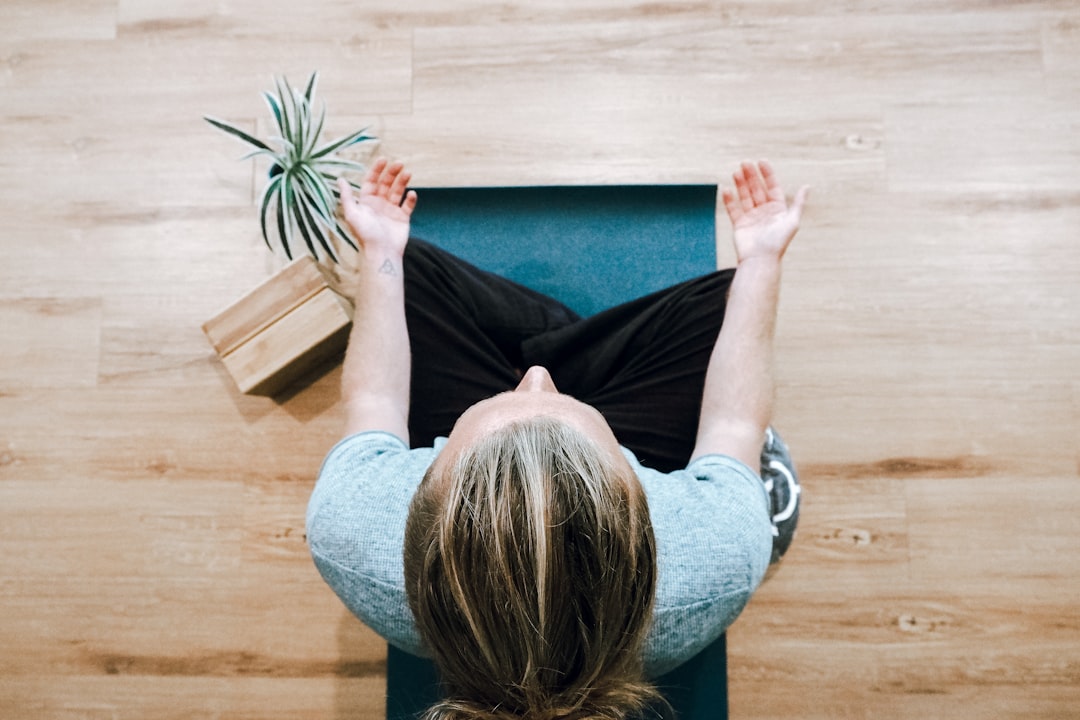 woman-in-black-shirt-and-gray-pants-sitting-on-brown-wooden-bench-6clboiwuzsu